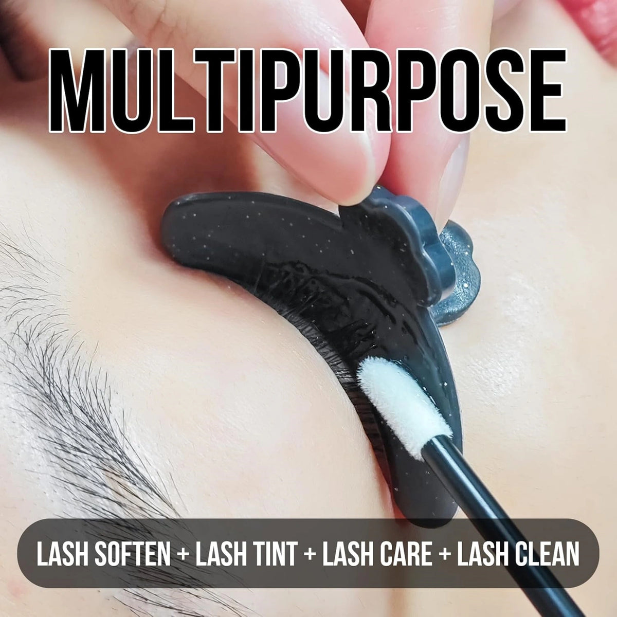 Close-up of a black eyelash shield held beneath lashes while a white applicator applies a lash treatment.