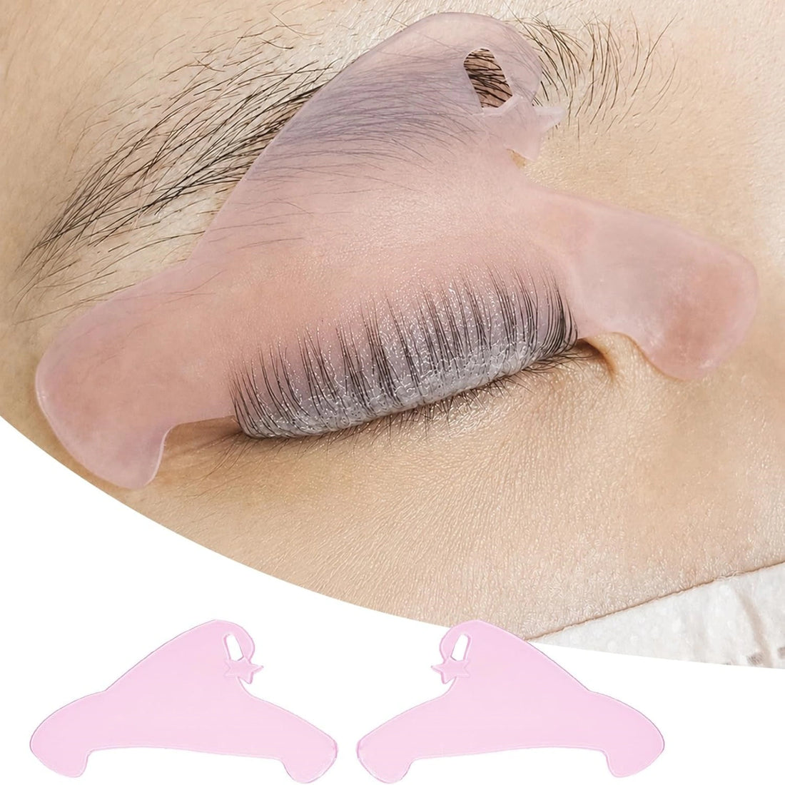 Pink flat lash lift shield on an eyelid with lashes combed upward, plus a matching pair of shields below.