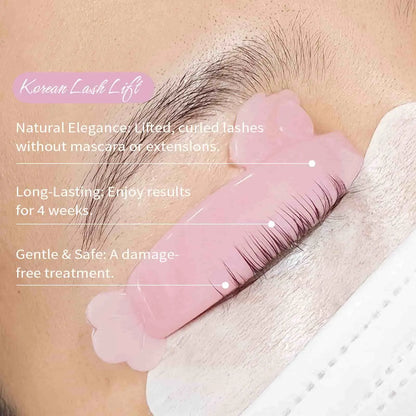 Pink lash lift shield positioned on a closed eyelid with upper lashes arranged along its curved surface.