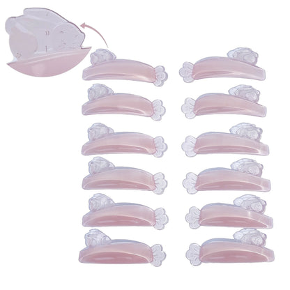 LOMANSA translucent pink Korean lash lift silicone shields with curved pads and flower-shaped ends arranged in two rows.