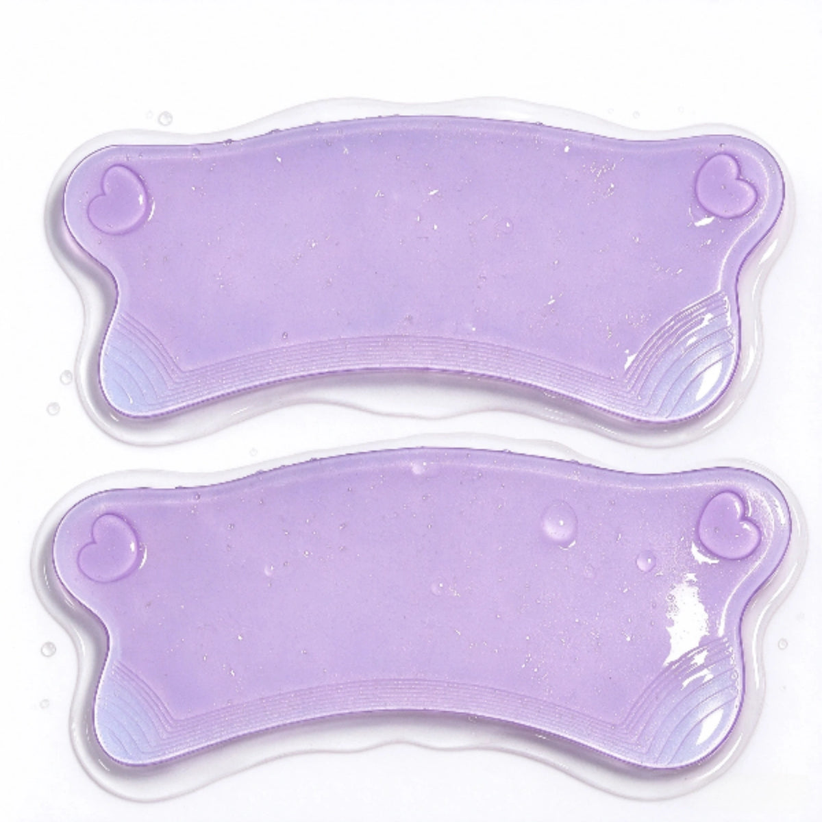 Close-up of two LOMANSA purple lash lift pads with heart-shaped details and curved textured edges.