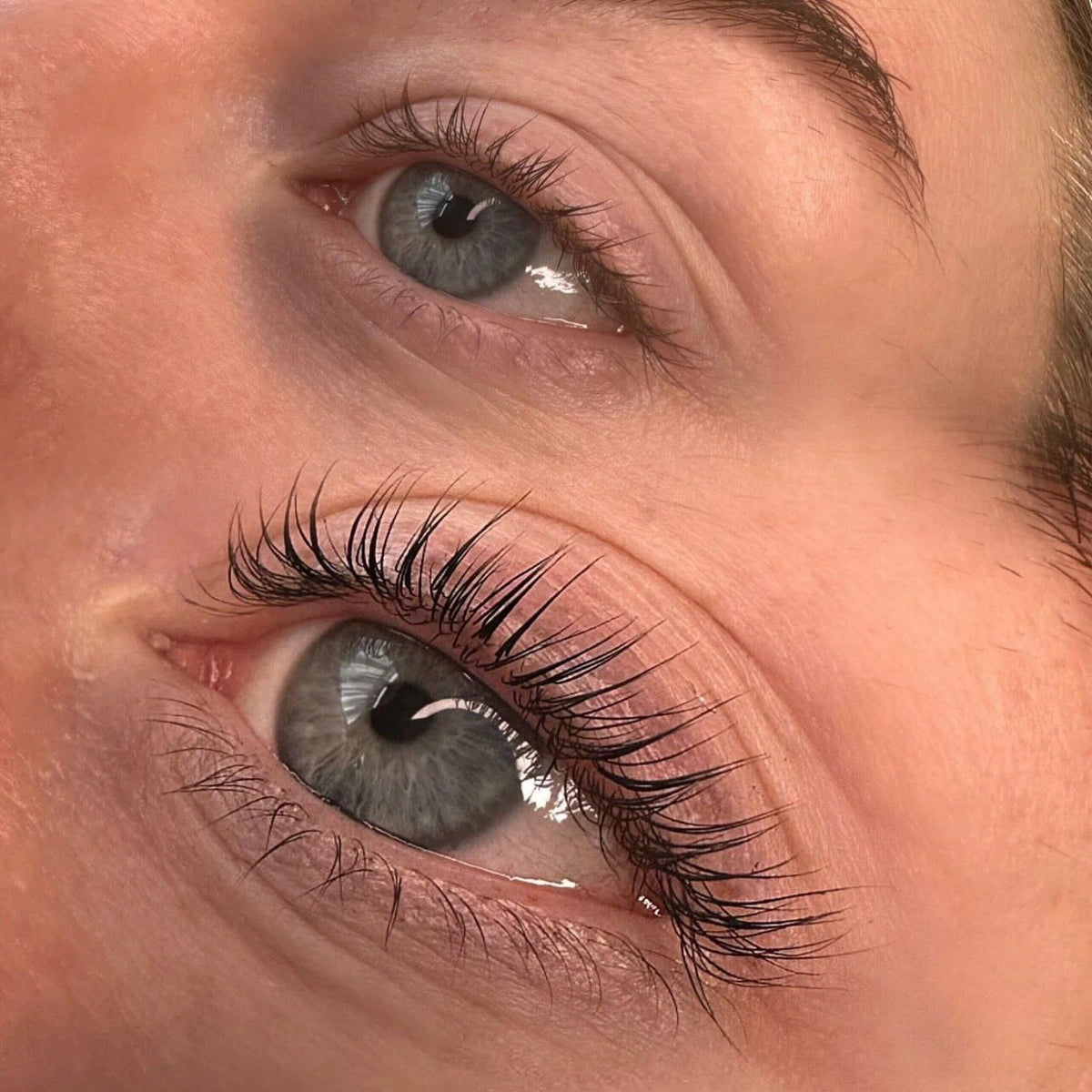 Close-up comparison of natural lashes and lifted, curled lashes showing the effect of a lash lift treatment.