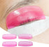 Pink LOMANSA silicone lash lift shield on an eyelid with lashes aligned over the pad, plus four numbered shields.
