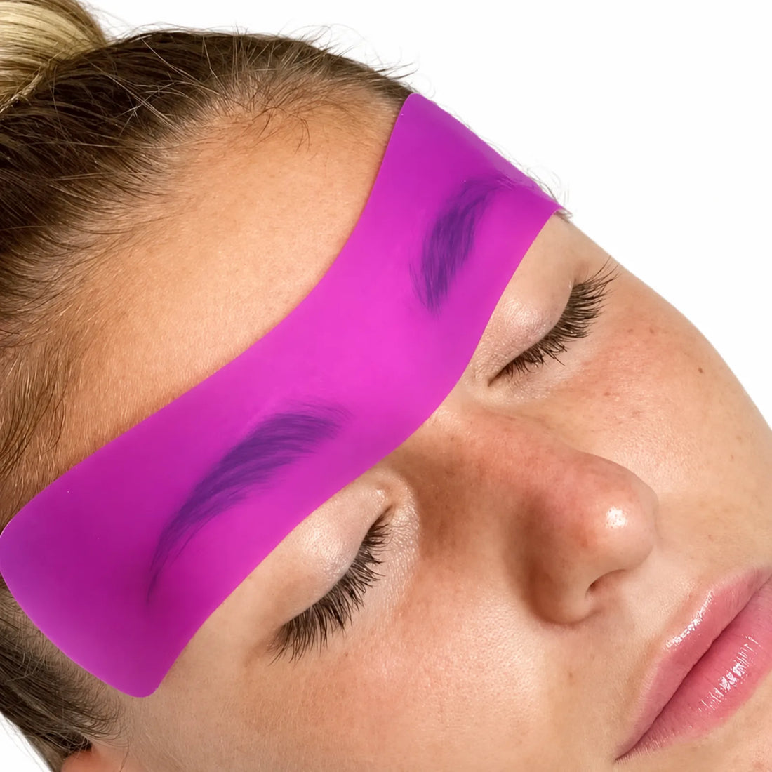 Lomansa pink silicone brow lift patch placed across both eyebrows during a brow lamination treatment.