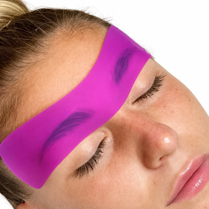 Lomansa pink silicone brow lift patch placed across both eyebrows during a brow lamination treatment.