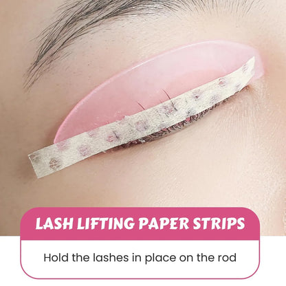 Lomansa lash lift paper strips holding eyelashes against a pink silicone shield during a lash lift treatment.