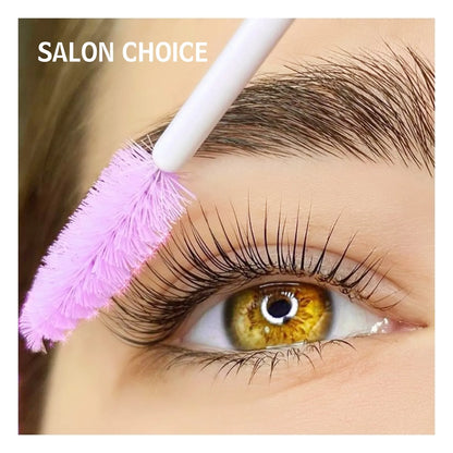 Close-up of lifted eyelashes and a pink spoolie brush grooming the eyebrow in a salon beauty image.