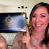 Woman presenting a black Lomansa 4-in-1 lash and brow lift and tint kit box with ornate gold details.