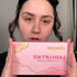 Woman holding a pink Lomansa lash lift kit box with gold accents and a cloud-shaped border design.